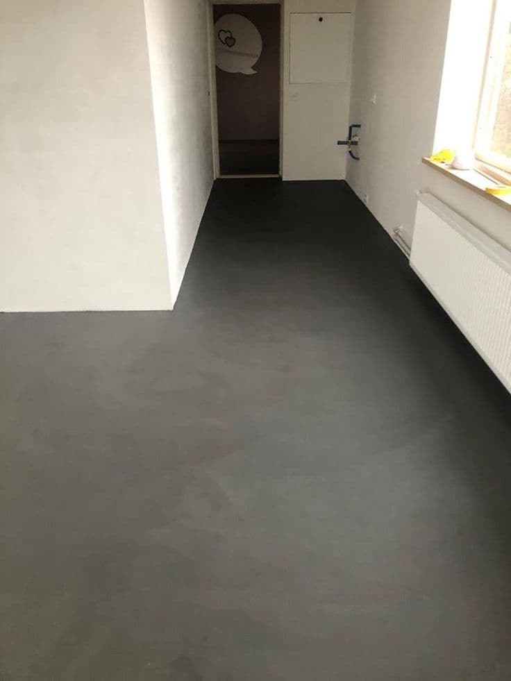 Moisture-Resistant Microcement Flooring Basements in Riyadh Sleek charcoal grey matte finish Microcement Flooring in a renovated basement hallway, seamless Microcement Floor installation by Floroz KSA.
